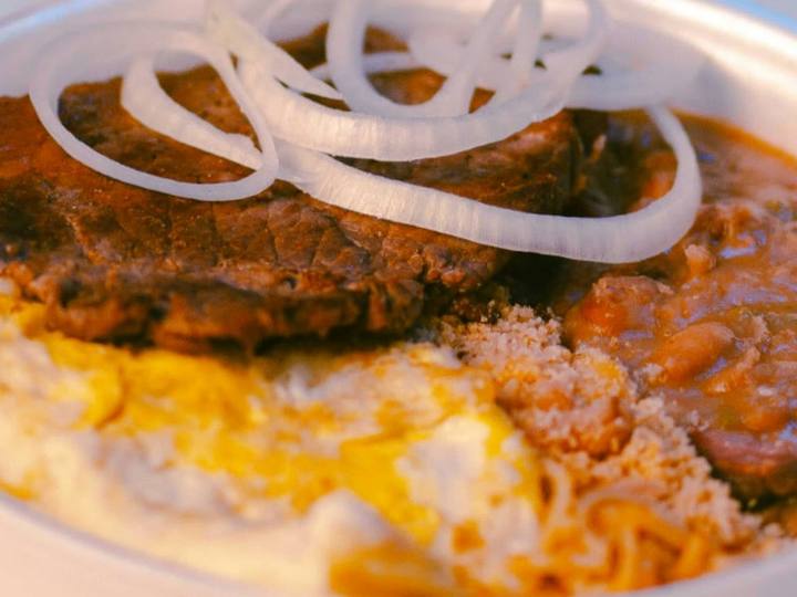 Carne de panela com cebola crua, feijão, farofa e ovo frito