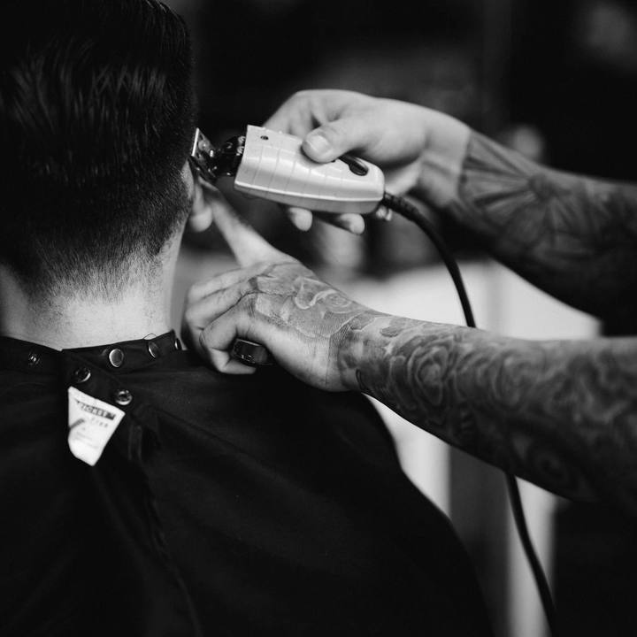 Máquina de cortar cabelo acertando a nuca de um cliente