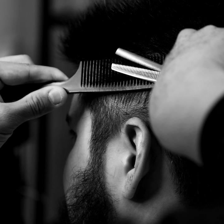 Tesoura de desbaste e pente aparando o cabelo